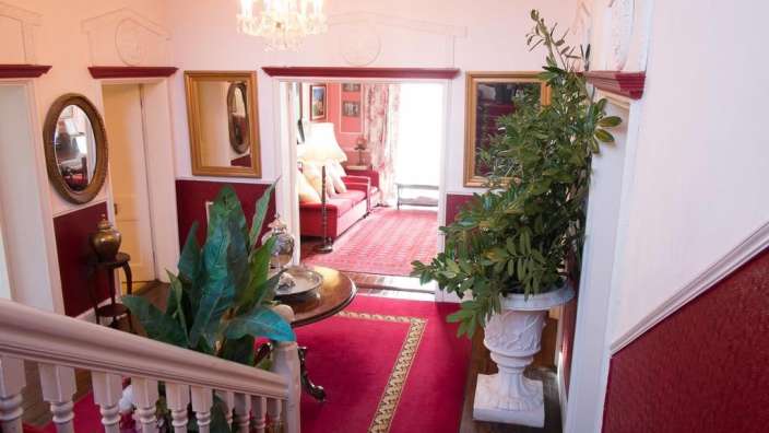 Ein Treppenhaus mit einem roten Teppich und einem Tisch