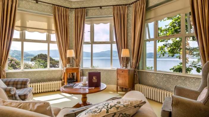 Ein Wohnzimmer mit vielen Fenstern und einem Tisch