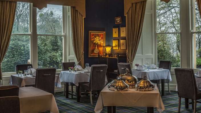 Ein Esszimmer mit vielen Tischen und Stühlen