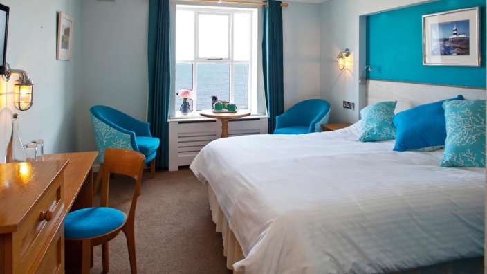 Ein Hotelzimmer mit einem Bett und zwei Stühlen