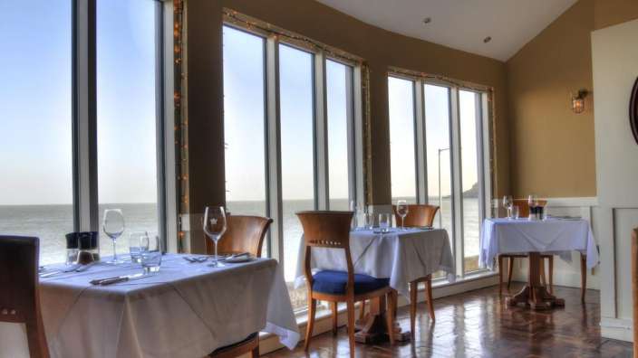 Tische und Stühle in einem Restaurant mit Blick auf das Meer