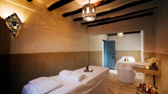 Ein Raum mit zwei Massagetischen und einem Waschbecken