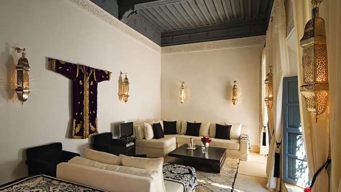 Ein Wohnzimmer mit weißen Möbeln und schwarzen Kissen