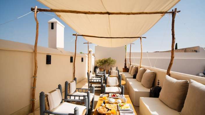 Ein Tisch und Stühle unter einem weißen Dach