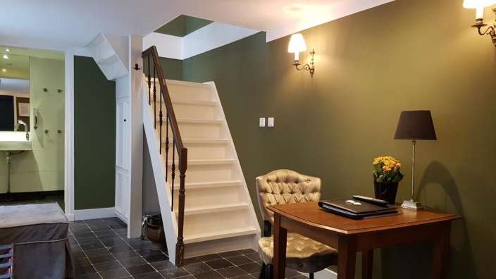 Ein Raum mit einem Tisch und einem Stuhl und einer Treppe