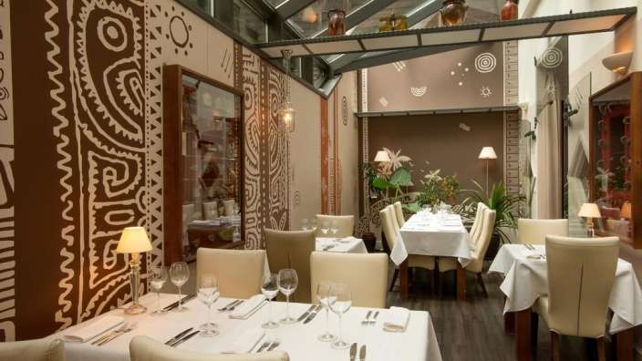 Ein Esszimmer mit weißen Tischen und Stühlen