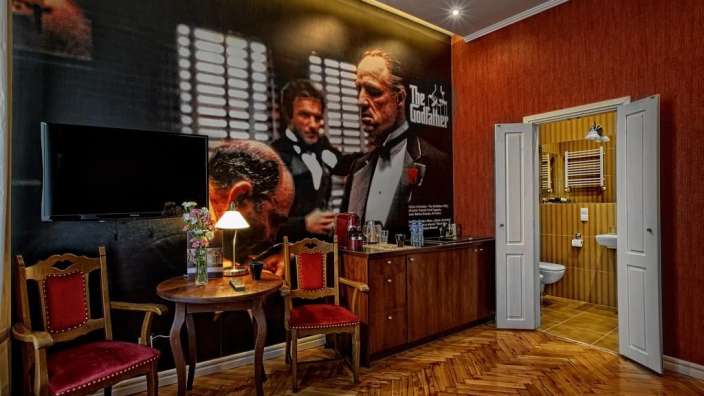 Ein Schlafzimmer mit einem großen Bild von einem Mann darauf und einem Schild mit der Aufschrift " der Gottvater "