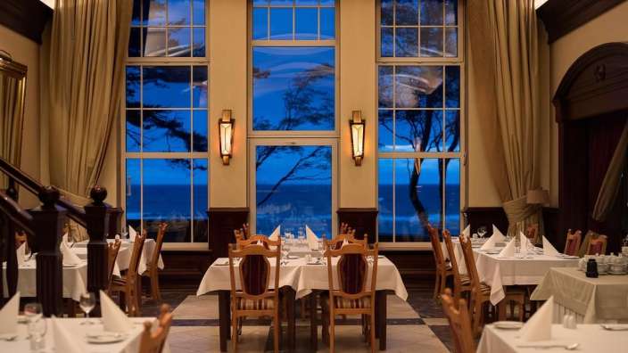 Tische und Stühle in einem Restaurant mit Blick auf das Meer