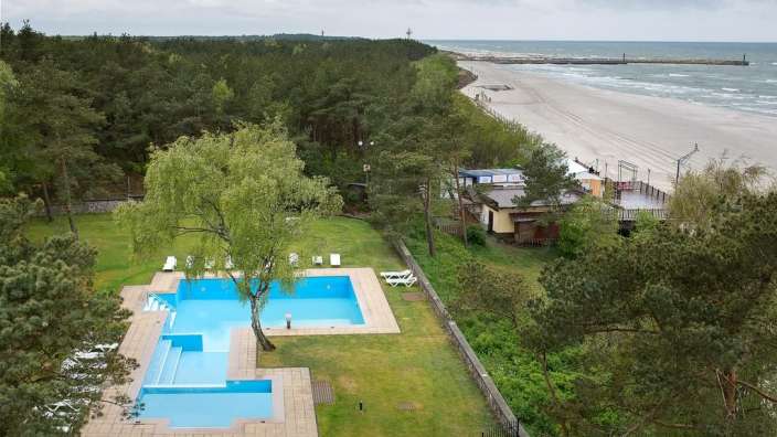 Ein großer blauer Pool neben einem Strand