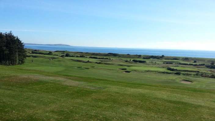 Ein Golfplatz mit Blick auf das Meer an einem sonnigen Tag