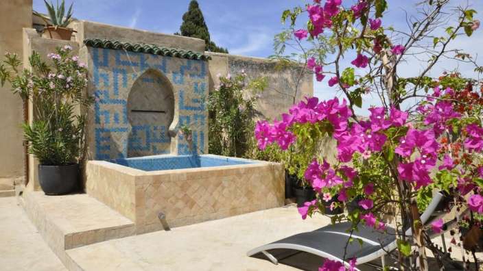 Ein Pool mit einem blauen und weißen Mosaik dahinter