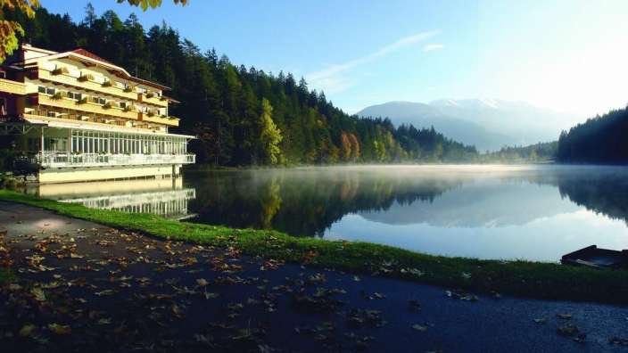 Ein Hotel neben einem See mit Bergen im Hintergrund