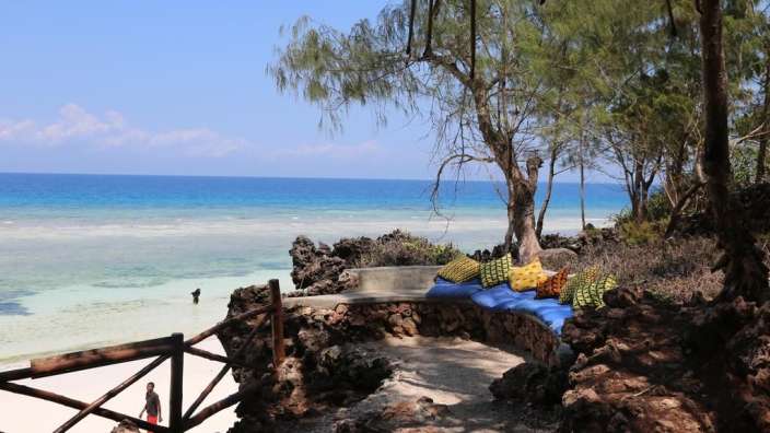 Ein Mann steht am Strand und schaut auf das Meer