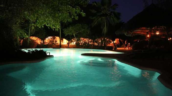 Ein großer Swimmingpool leuchtet in der Nacht