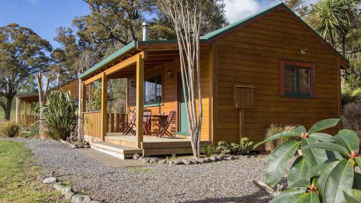 Ein kleines Holzhaus mit einem Tisch und Stühlen auf der Veranda