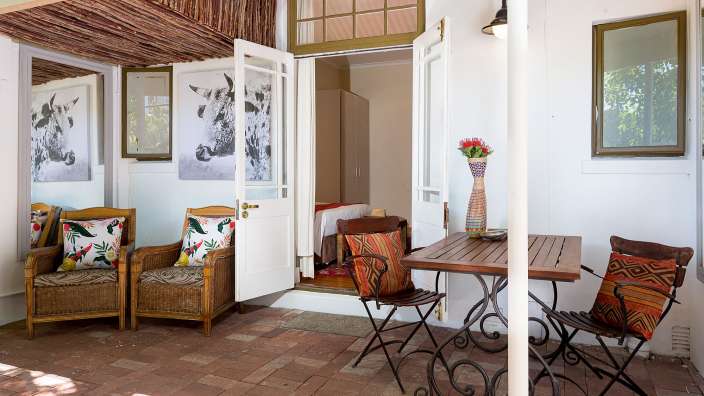 Ein Tisch und Stühle stehen auf einer Terrasse neben einer Tür