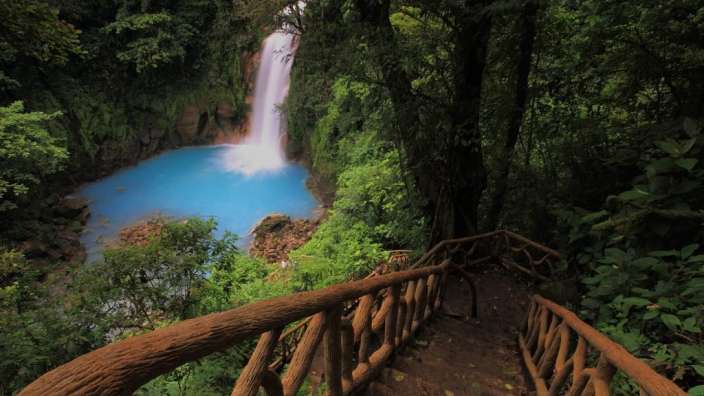 Eine Holztreppe führt hinunter zu einem Wasserfall