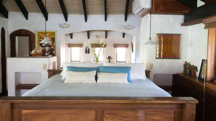 Ein Schlafzimmer mit einem Holzbett und blauen und weißen Kissen
