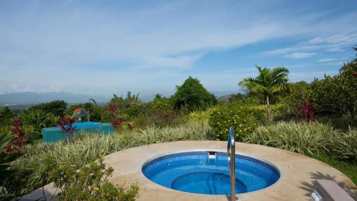 Ein großer blauer Pool in einem Garten mit Blick auf die Berge