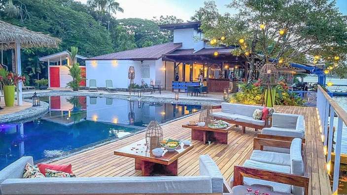 Ein Deck mit Möbeln und einem Swimmingpool im Hintergrund