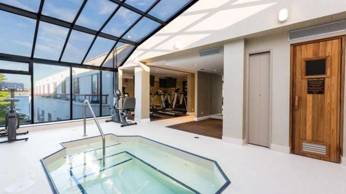 Ein Fitnessstudio mit einem Whirlpool und einer Sauna