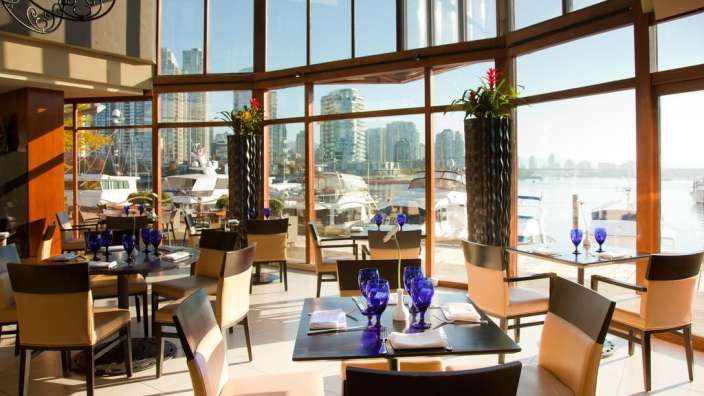 Tische und Stühle in einem Restaurant mit Blick auf das Wasser