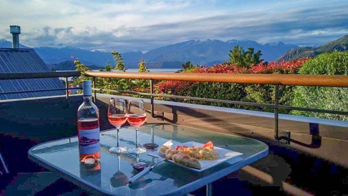 Eine Flasche roséwein steht auf einem glastisch neben zwei gläsern