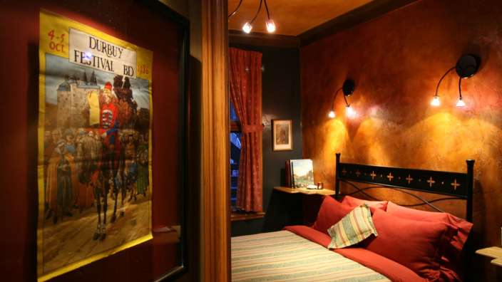 Ein Poster hängt an einer Wand neben einem Bett