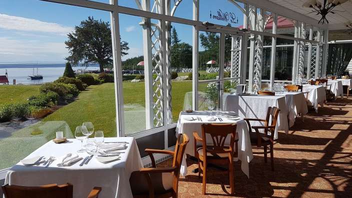 Tische und Stühle in einem Restaurant mit einem Schild an der Wand , das sagt ' a '