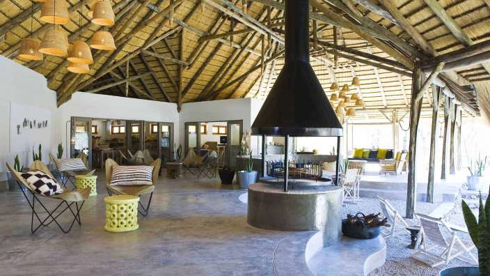 Ein Wohnzimmer mit einem schwarzen Kamin und einem Strohdach