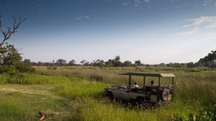 Ein jeep fährt durch einen grasbewachsenen feld