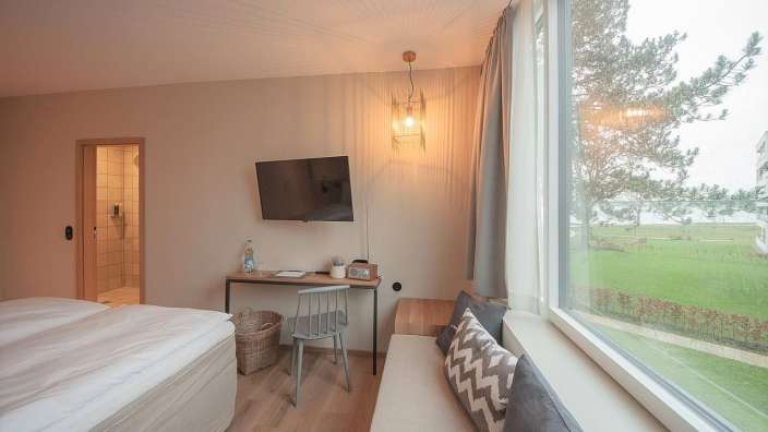 Ein Zimmer mit einem Bett, einem Schreibtisch und einem Fernseher