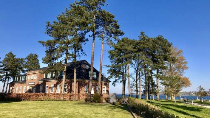 Ein großes Backsteinhaus mit Bäumen davor