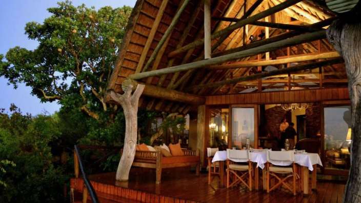 Ein großes Holzhaus mit einem Tisch und Stühlen darauf