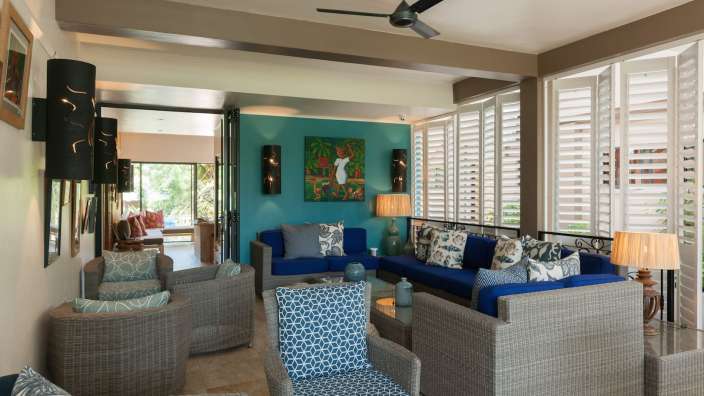 Ein Wohnzimmer mit vielen Möbeln und einem Deckenventilator