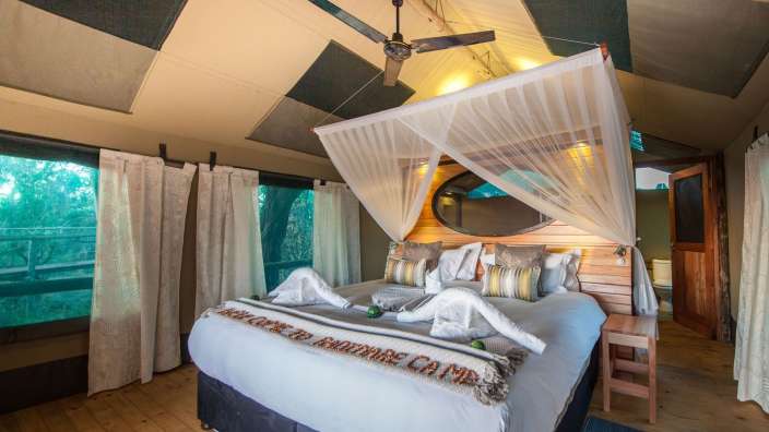 Ein Bett in einem Zelt mit der Aufschrift " welcome to bartrade camp " darauf
