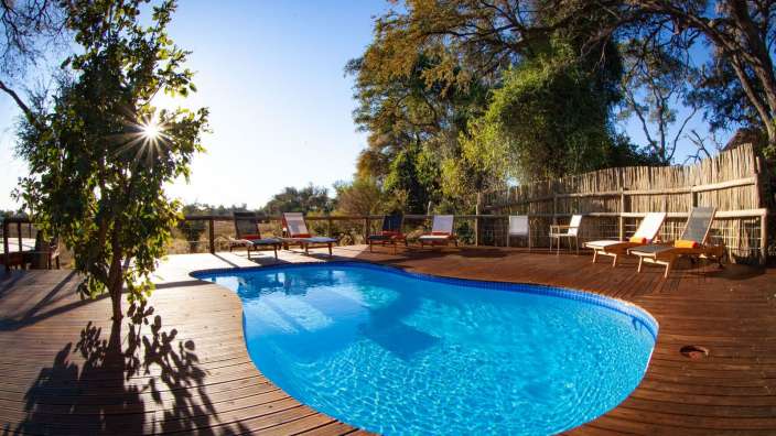 Ein großer blauer Pool auf einem Holzdeck