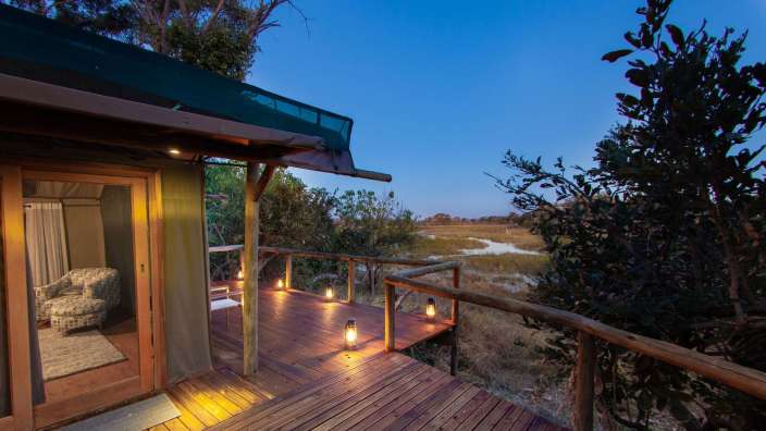 Eine Holzterrasse mit Laternen und einem Stuhl darauf