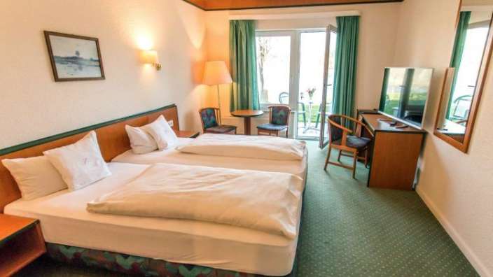 Ein Hotelzimmer mit zwei Betten und einem Fernseher