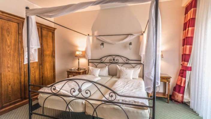 Ein Schlafzimmer mit einem Himmelbett und einer Lampe