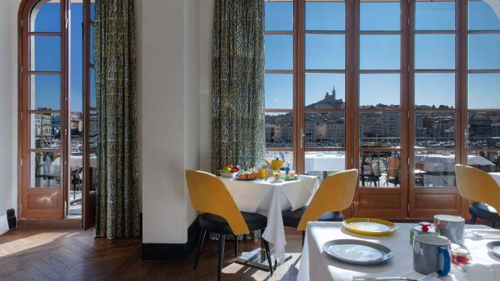 Ein Esszimmer mit einem Tisch und Stühlen und einem großen Fenster