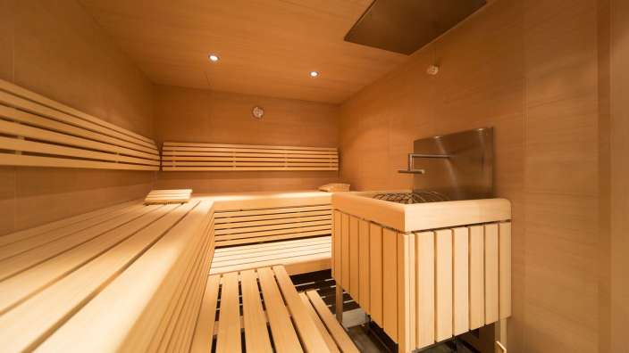 Eine Holzsauna mit einem Waschbecken in der Mitte