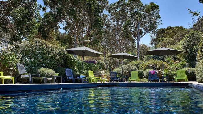 Ein Swimmingpool mit Stühlen und Sonnenschirmen umgeben