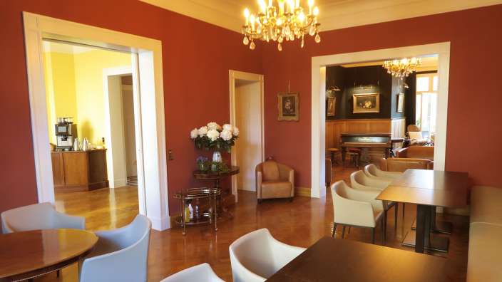 Ein Wohnzimmer mit roten Wänden und einem Kronleuchter