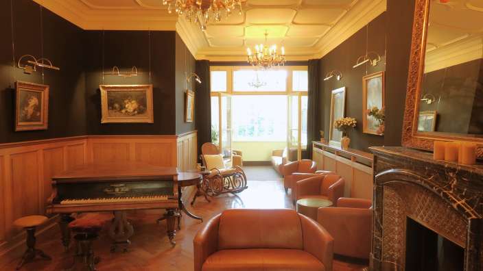 Ein Wohnzimmer mit einem Klavier und einem Stuhl