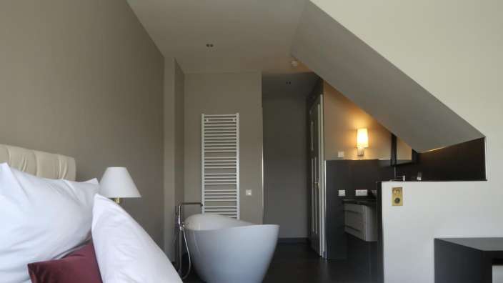 Ein Schlafzimmer mit einer Badewanne und einem Waschbecken