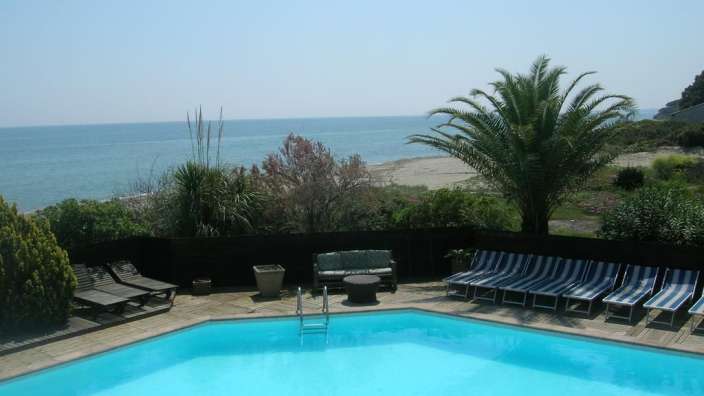 Ein großer Pool mit Liegestühlen und einer Couch davor