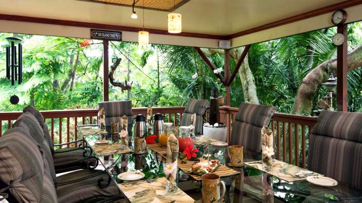 Ein Tisch und Stühle auf einer Veranda mit einem Schild darüber