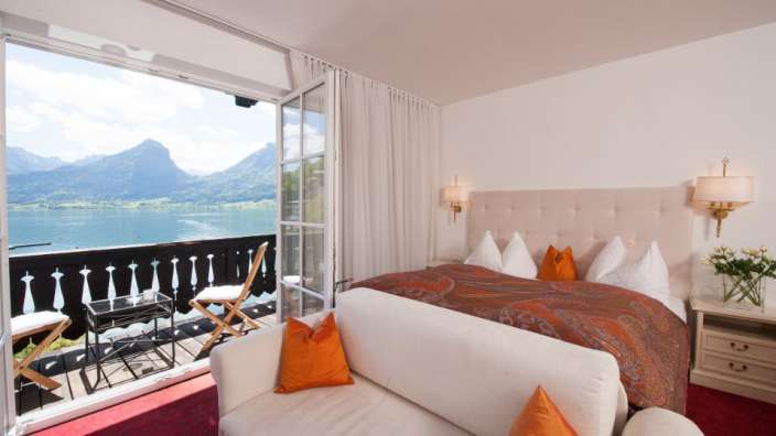 Ein Hotelzimmer mit einem Bett und einem Balkon mit Blick auf den See
