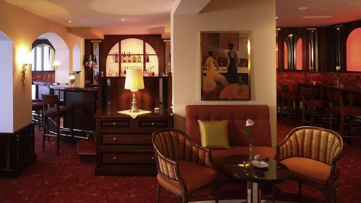 Ein Wohnzimmer mit einem Tisch und Stühlen und einem Gemälde an der Wand